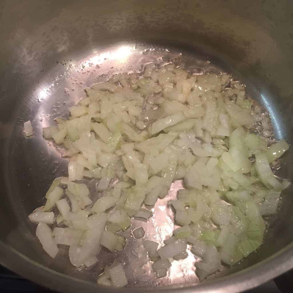 Diced onions sauteed in a stainless steel pot
