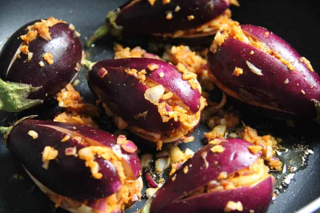 stuffed eggplant being cooked in a pan 