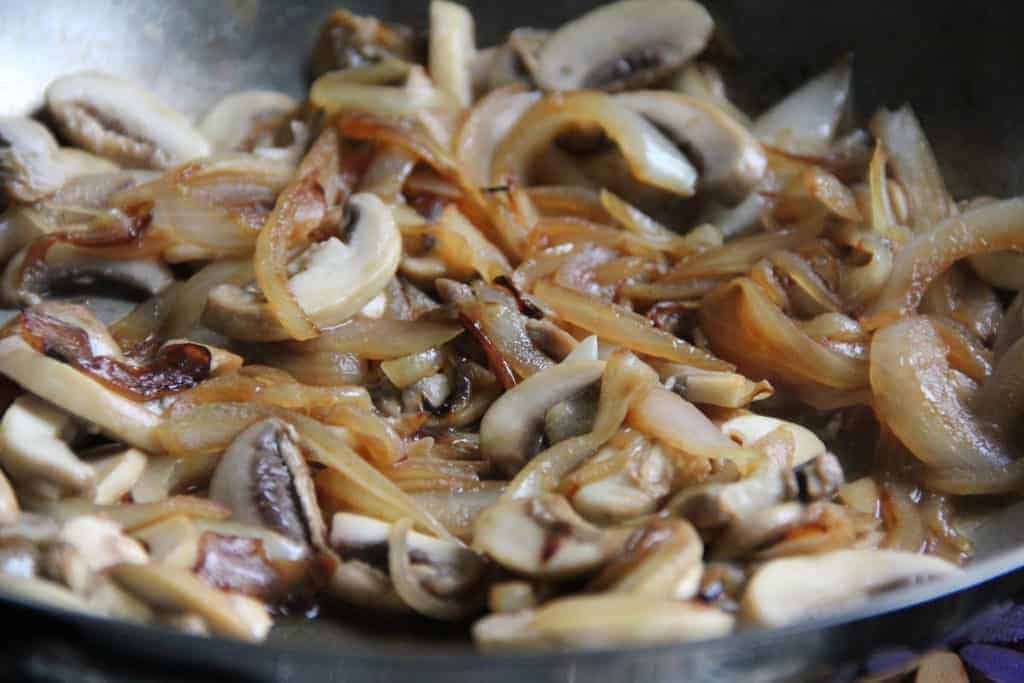 sauteed onions and mushrooms in a pan 
