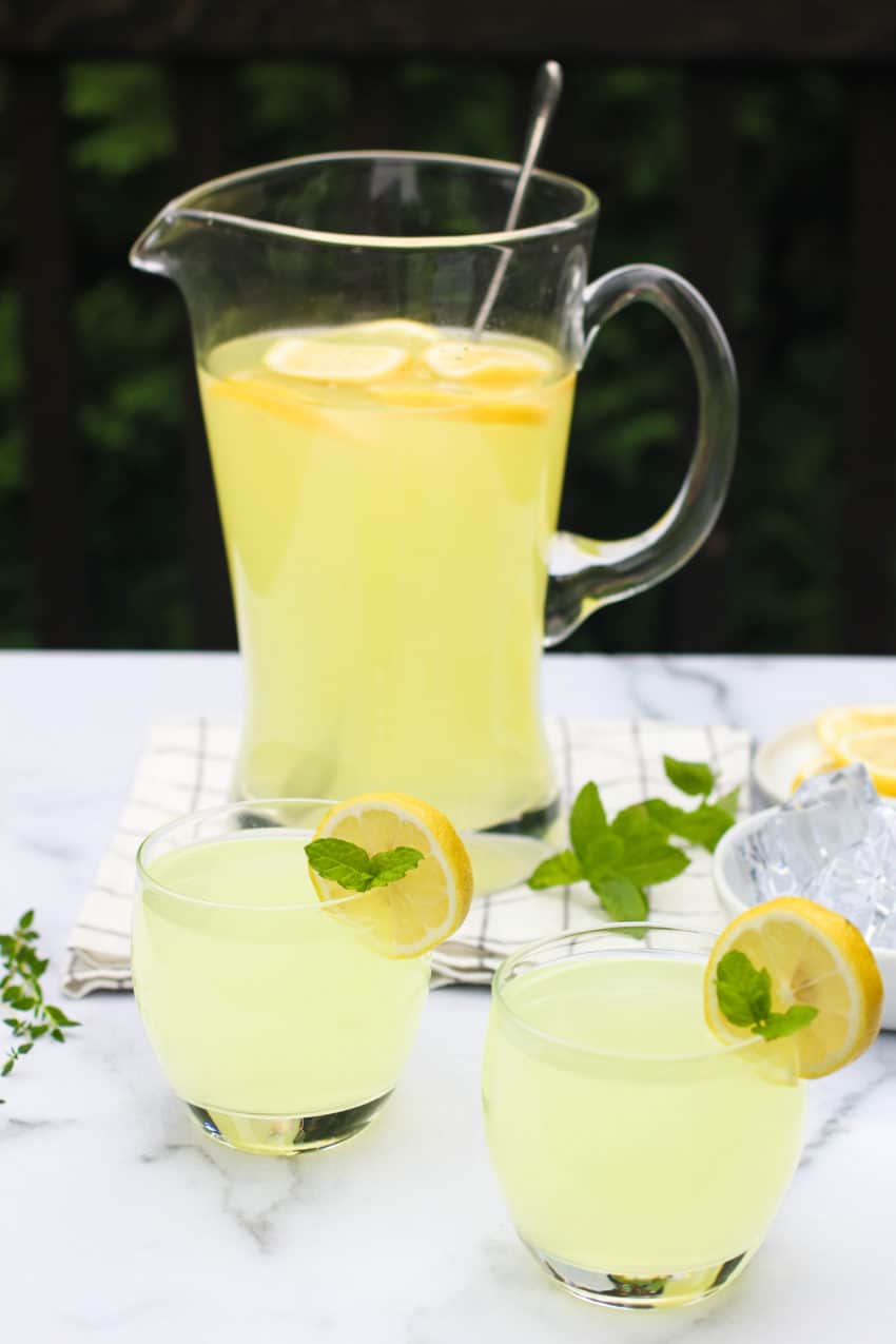 2 glasses and a large pitcher of lemonade