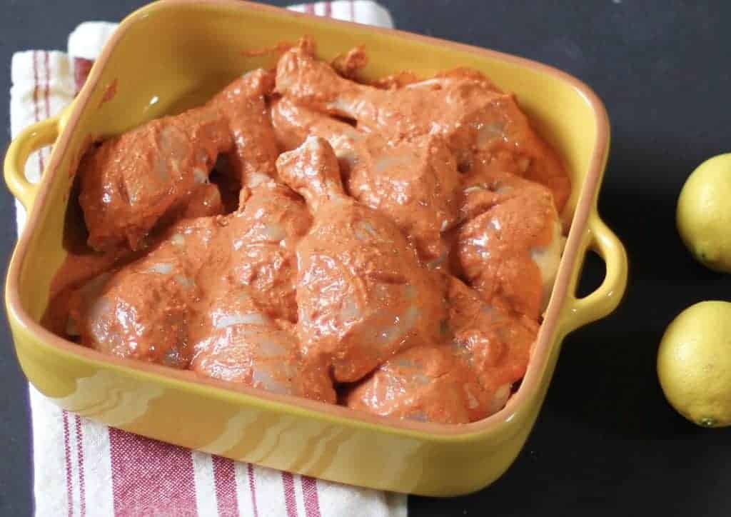 marinated raw tandoori chicken in yellow dish