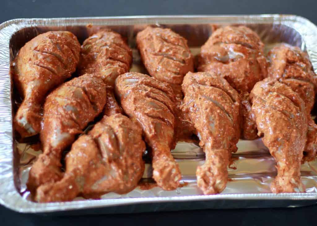 marinated raw tandoori chicken in aluminum tray