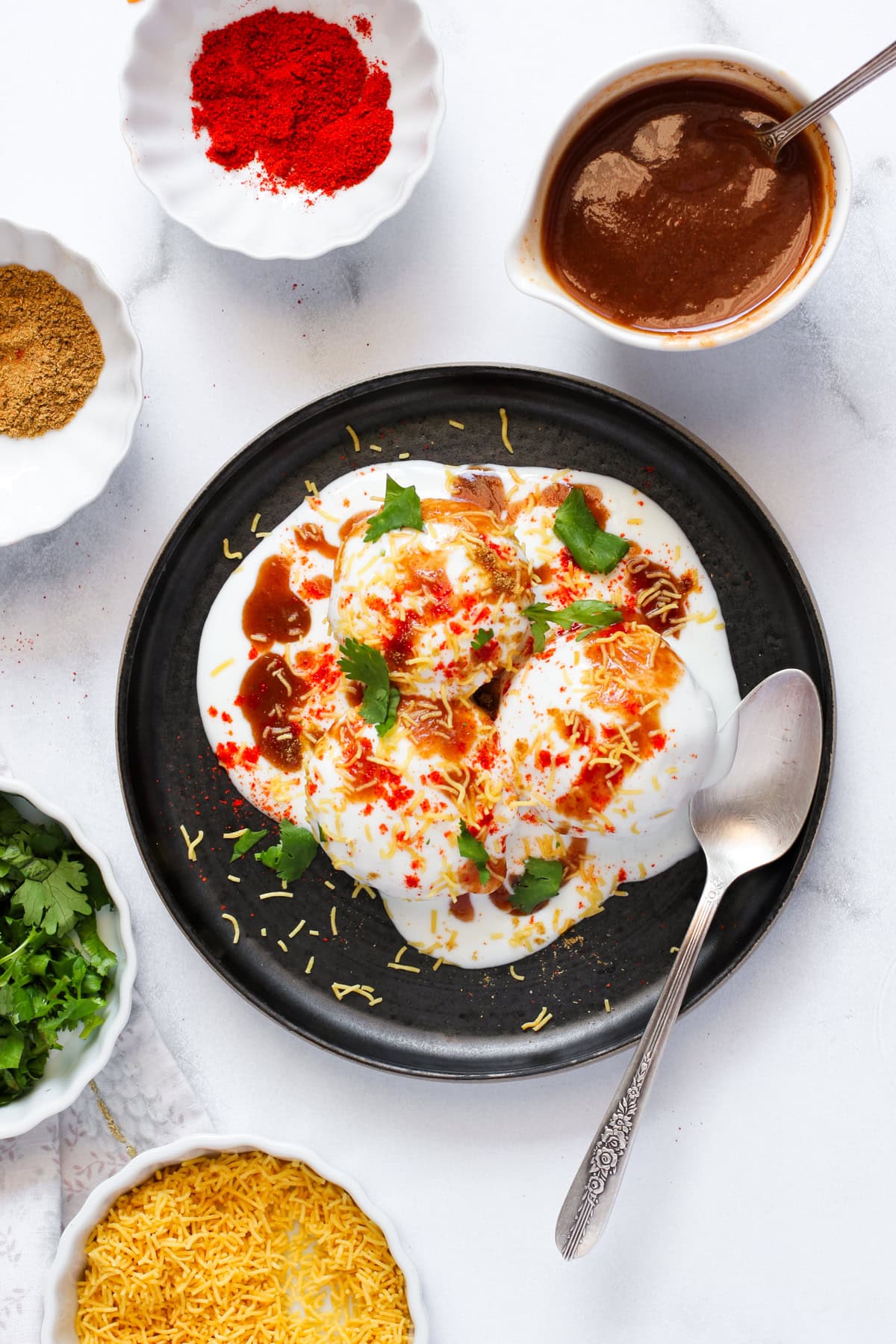 Dahi Vada garnished with spices and chutney 