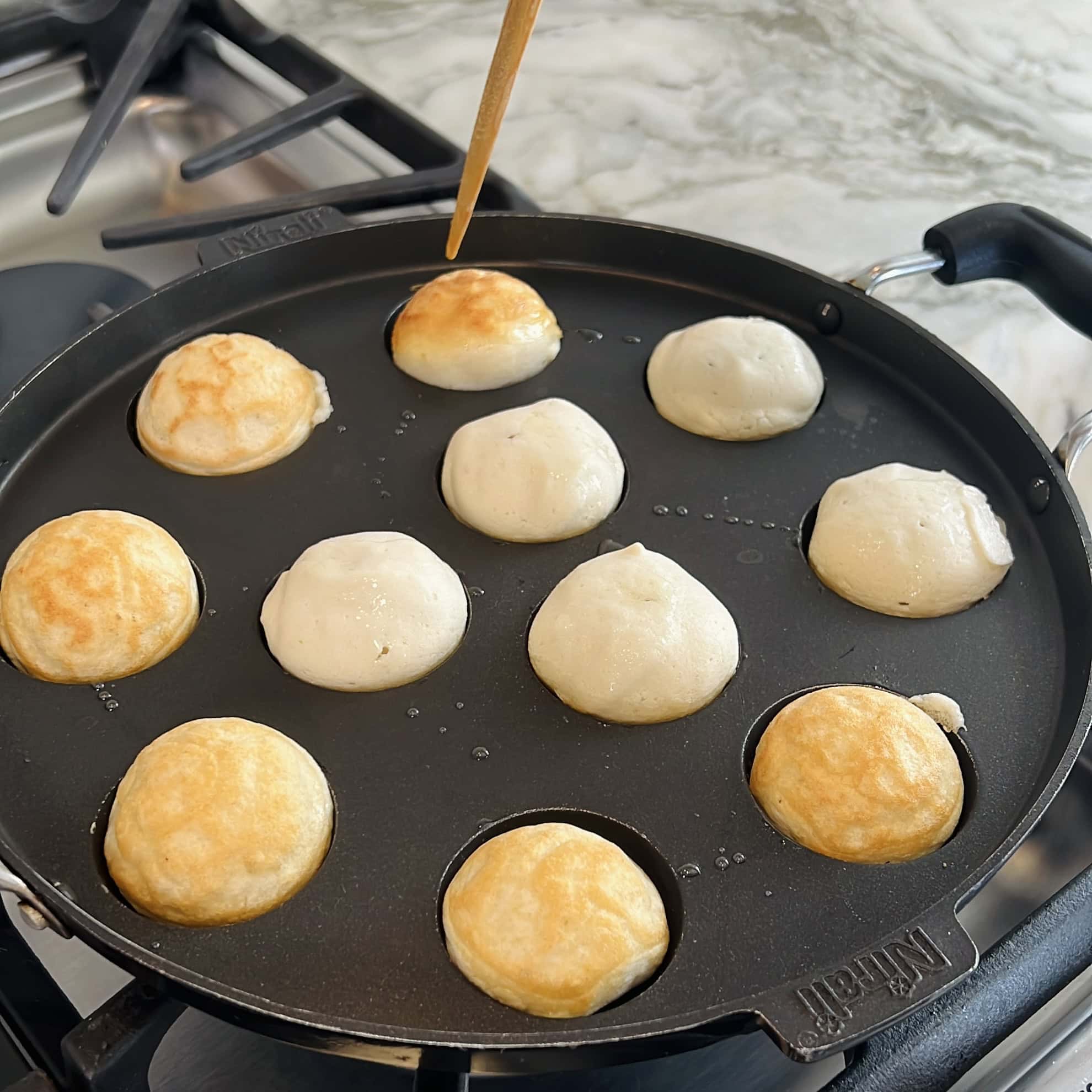 paniyaram pan with dahivadas cooked on one side 