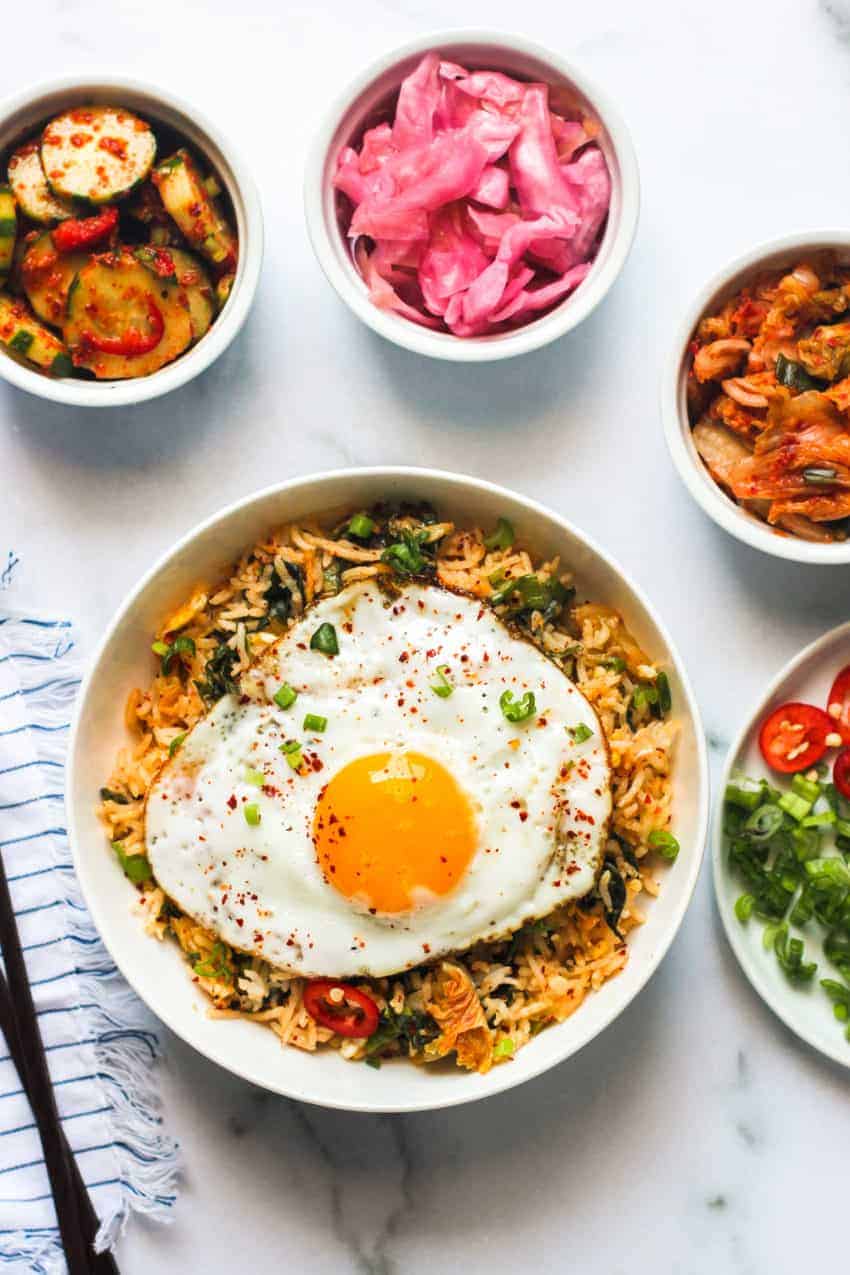 kimchi fried rice served in a white bowl with an egg on top