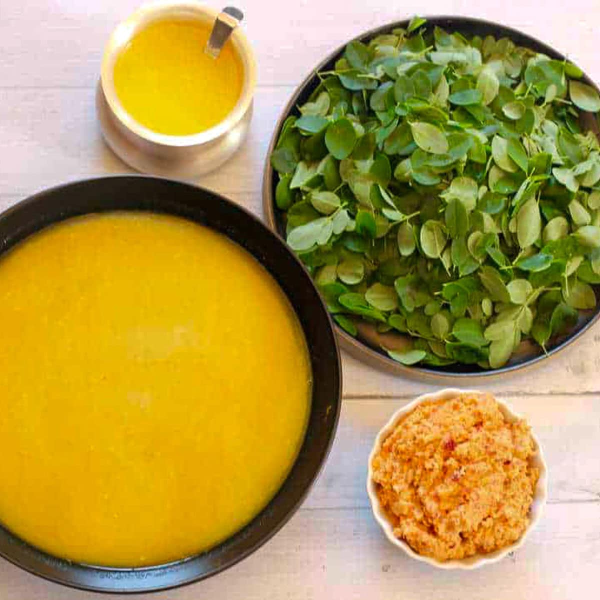 cooked lentils, masala paste, ghee and moringa leaves 
