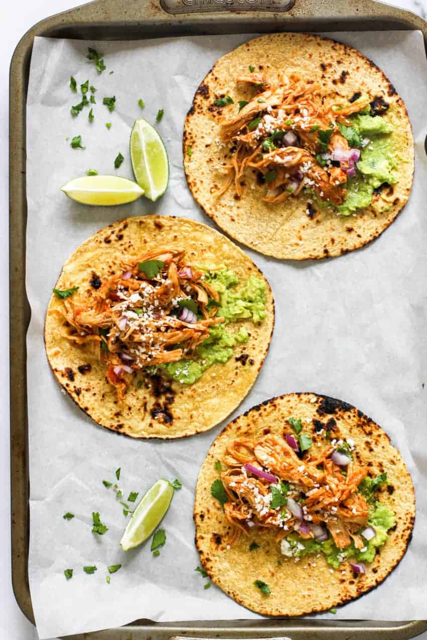 Chicken Tinga Tacos with lime wedges on the side