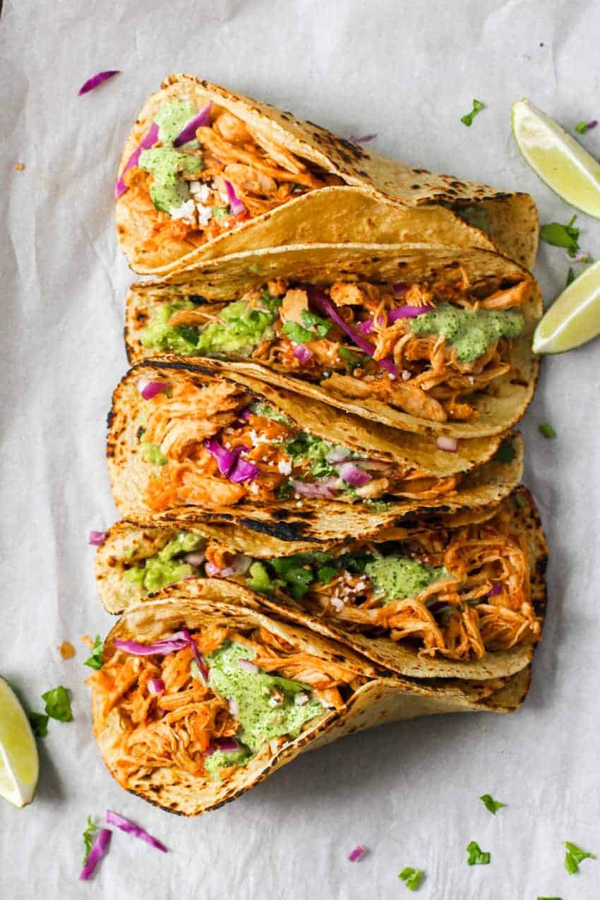 Chicken Tinga Tacos with lime wedges on the side