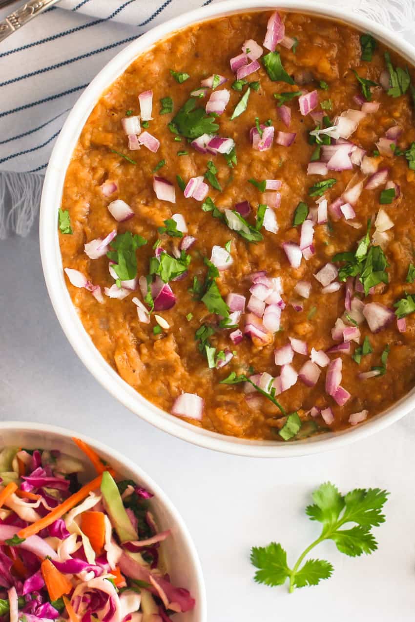 Misir Wot garnished with red onions and cilantro 