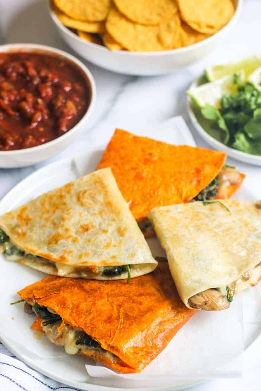 stack of spinach mushroom and onion quesadillas on a white plate