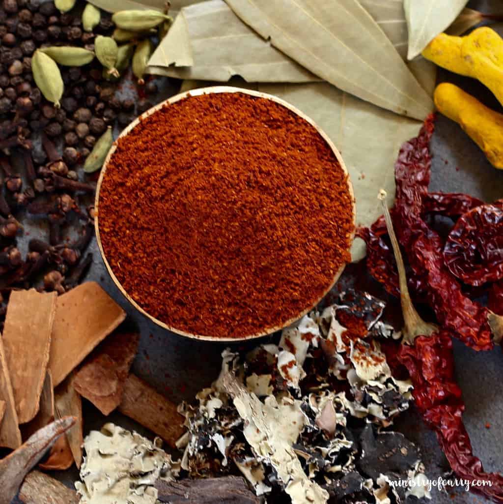 garam masala bowl and whole spices surrounding it 