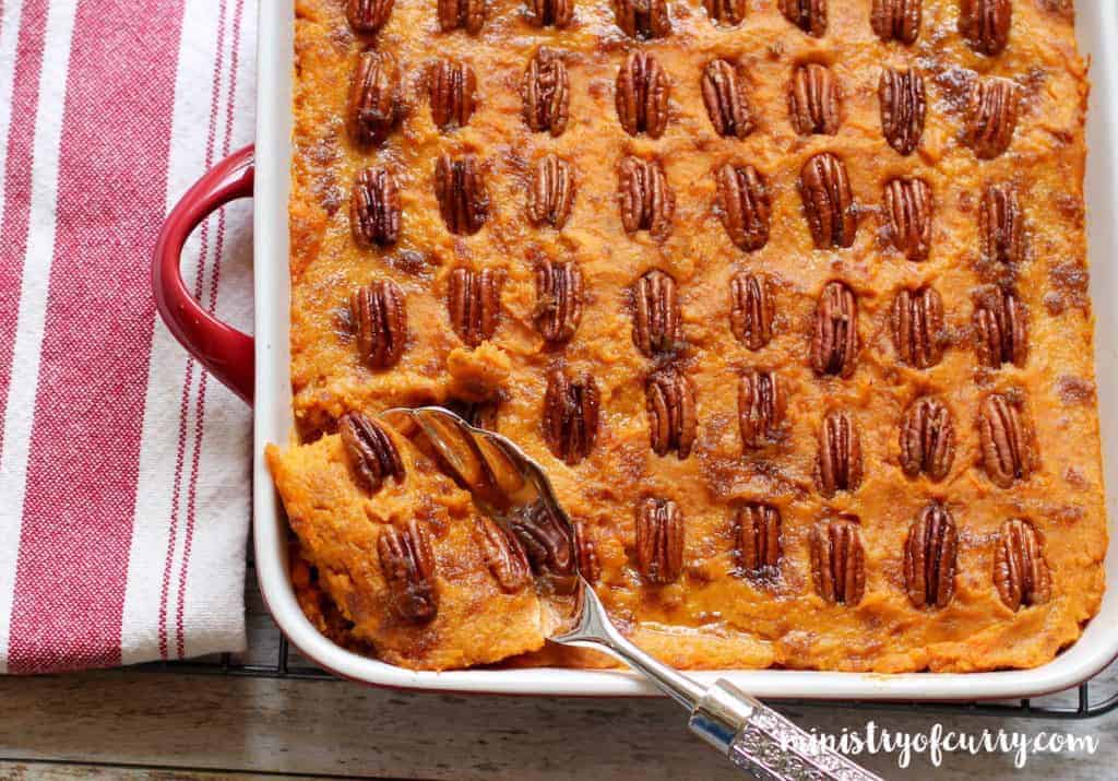 sweet potato casserole in a large serving dish with a serving spoon in it
