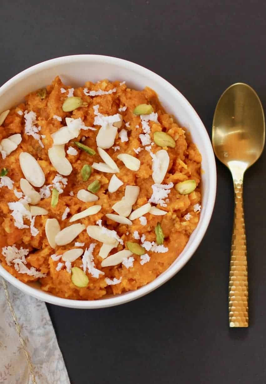 sweet potato halwa served in a white bowl with a spoon next to it