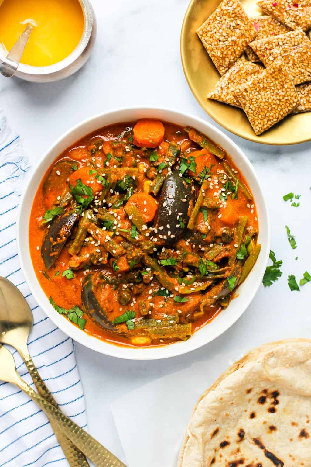 Bhogi chi Bhaji in a white bowl alongside roti and sesame chikki 