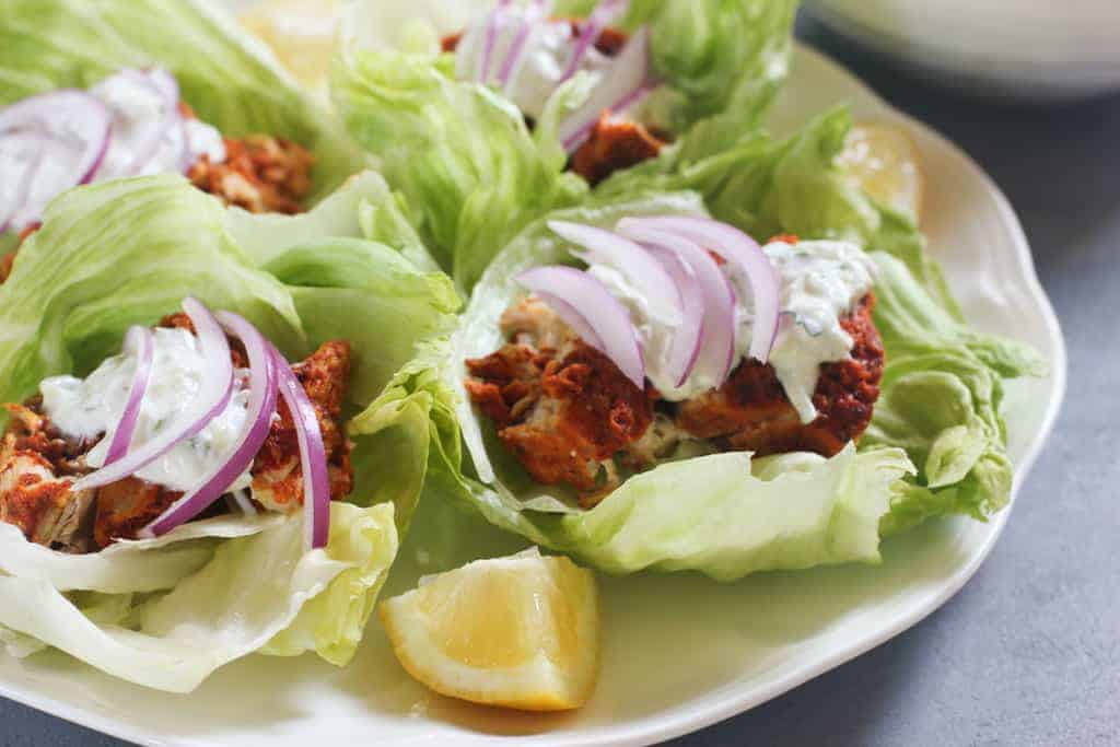 Tandoori Chicken Lettuce Wraps on white platter with lemon wedges