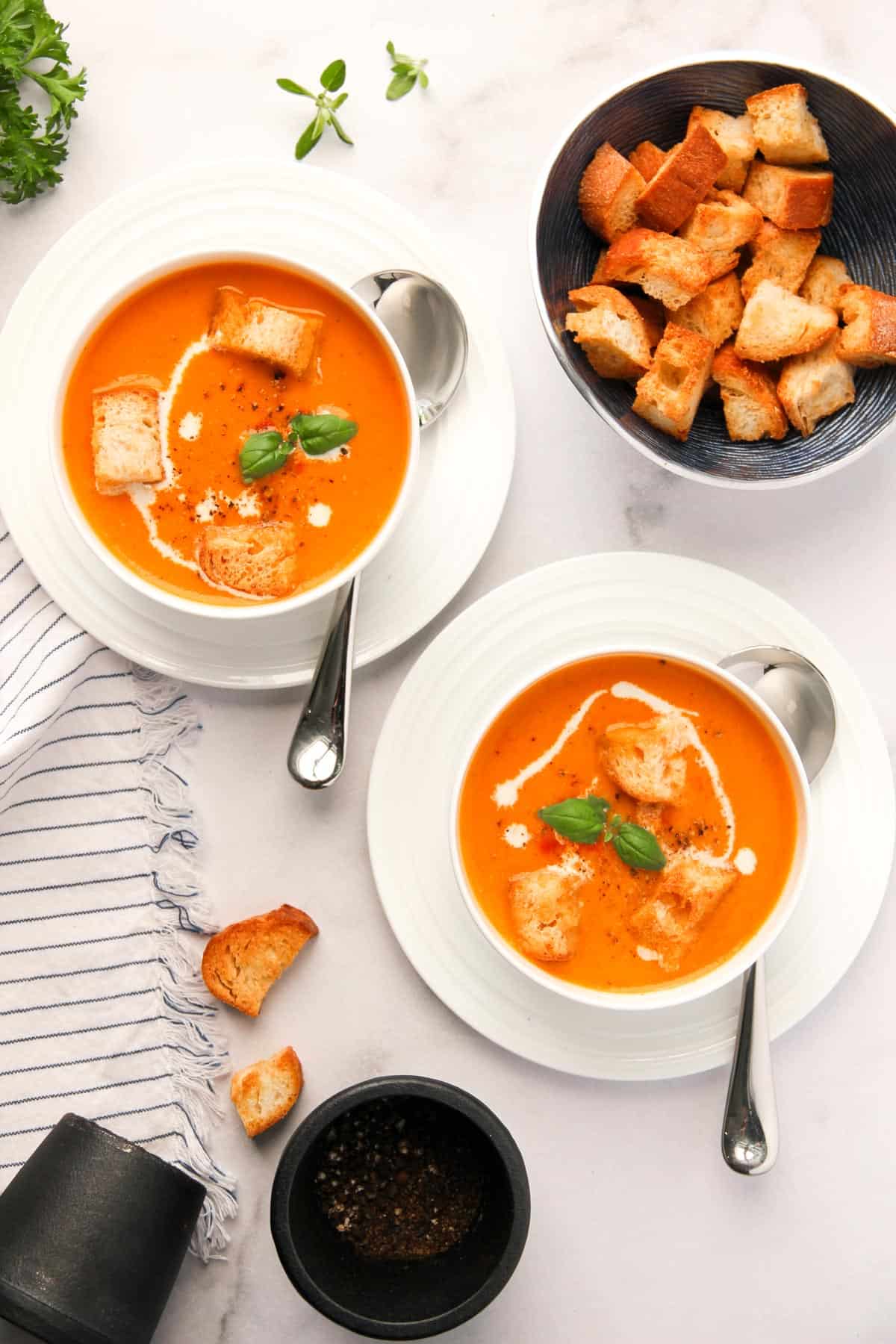 creamy tomato soup in 2 white bowls