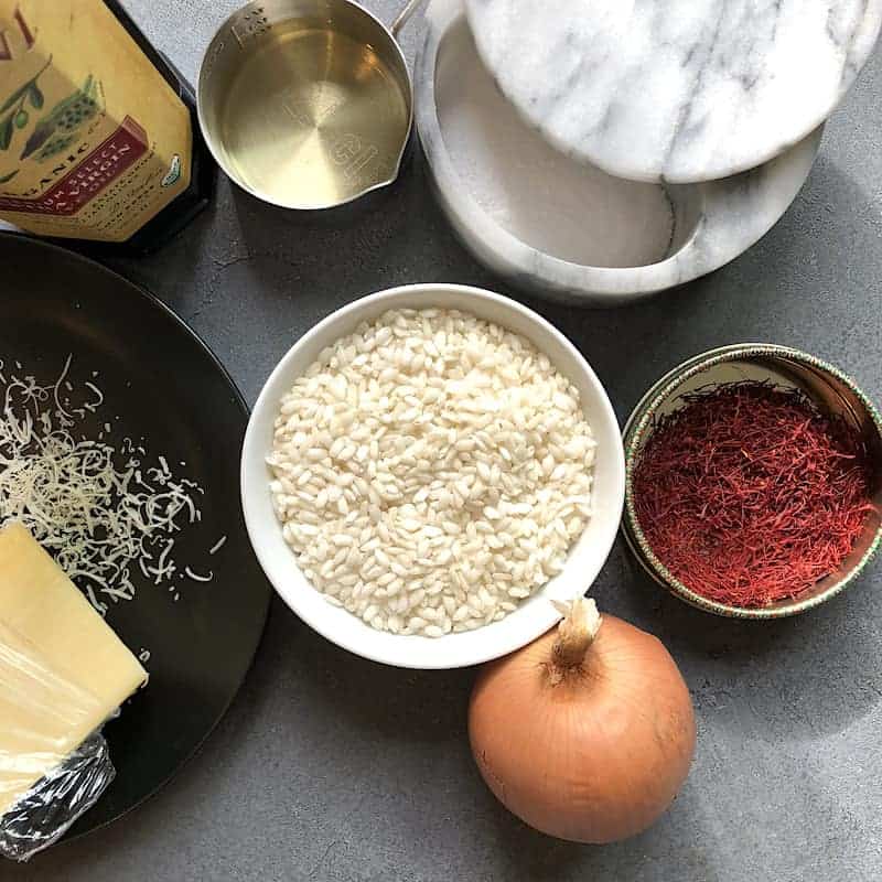 Ingredients for saffron risotto - rice, onion, saffron, wine, salt, oil and parmesan cheese