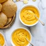 Mango Shrikhand seved in white bowls with Puri's on the side