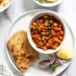 Chickpea Curry served with parathas, lemon wedge and sliced onions