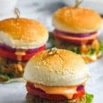 Three chicken burgers on buns with spicy sauce