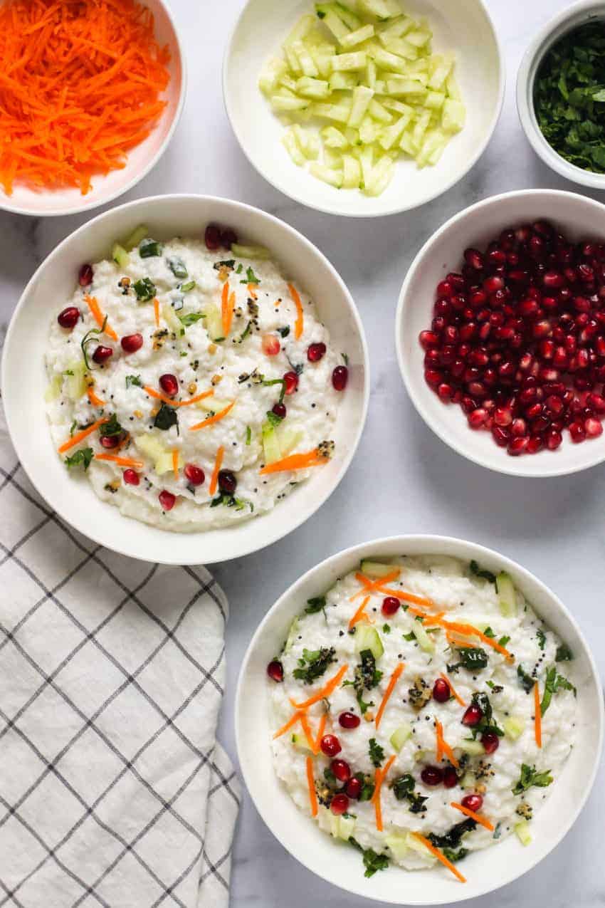 2 bowls of yogurt rice and bowls with garnish on the side