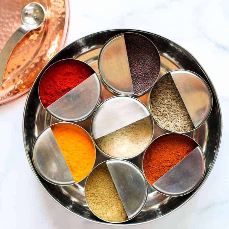 Spice box, masala dabba with individual bowls of whole and ground spices. 