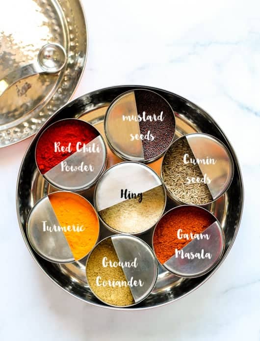 Indian Spice box, masala dabba with individual bowls of whole and ground spices. 