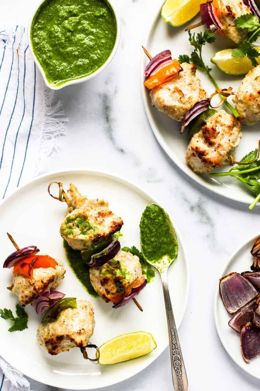 chicken kebab served with chutney in two white plates 