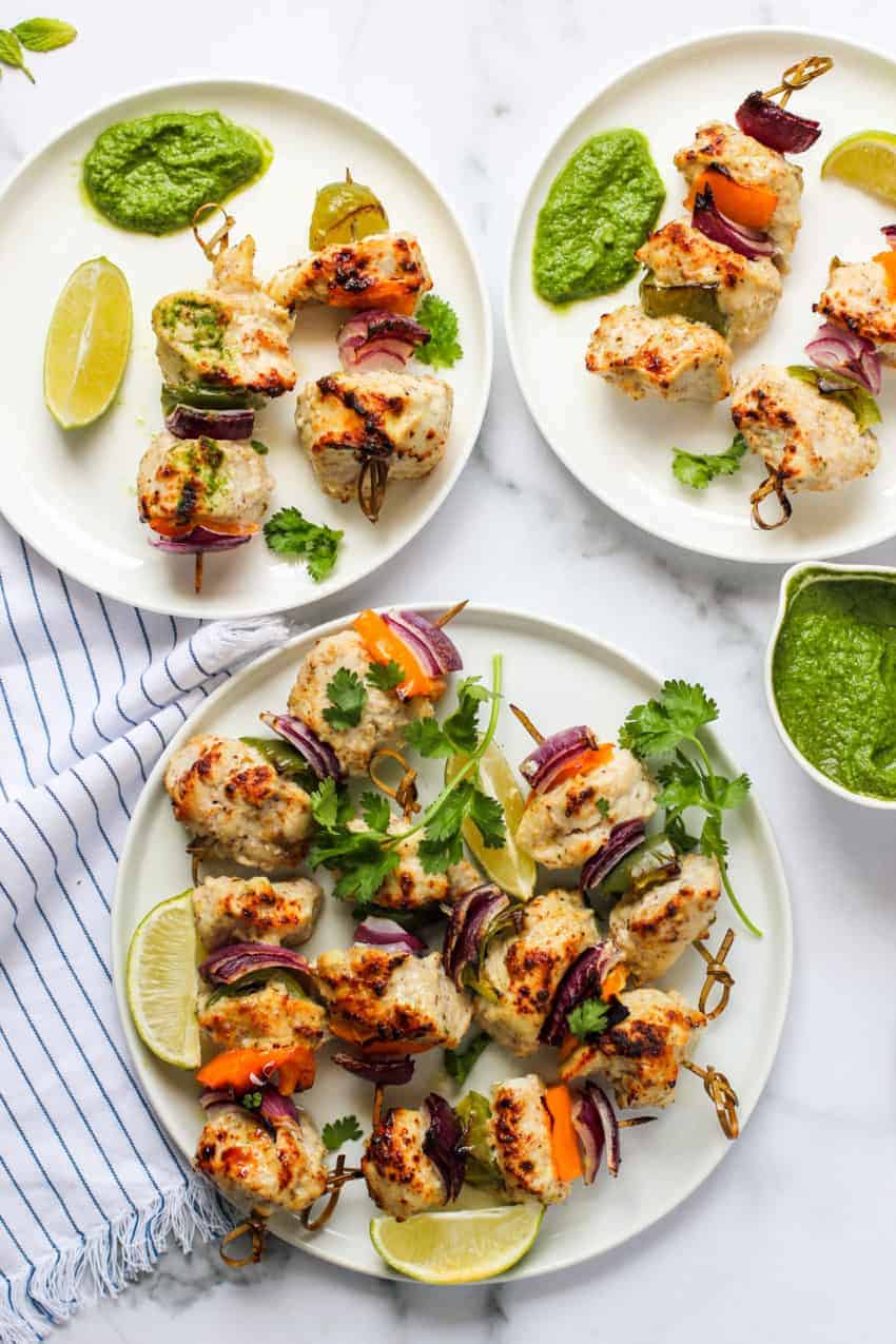chicken kebab served with chutney in white plates 