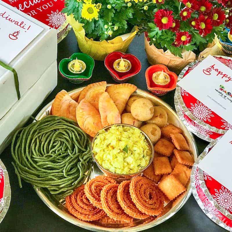 Diwali Sweets and Savories aka Faral in a platter with gift boxes on the side 