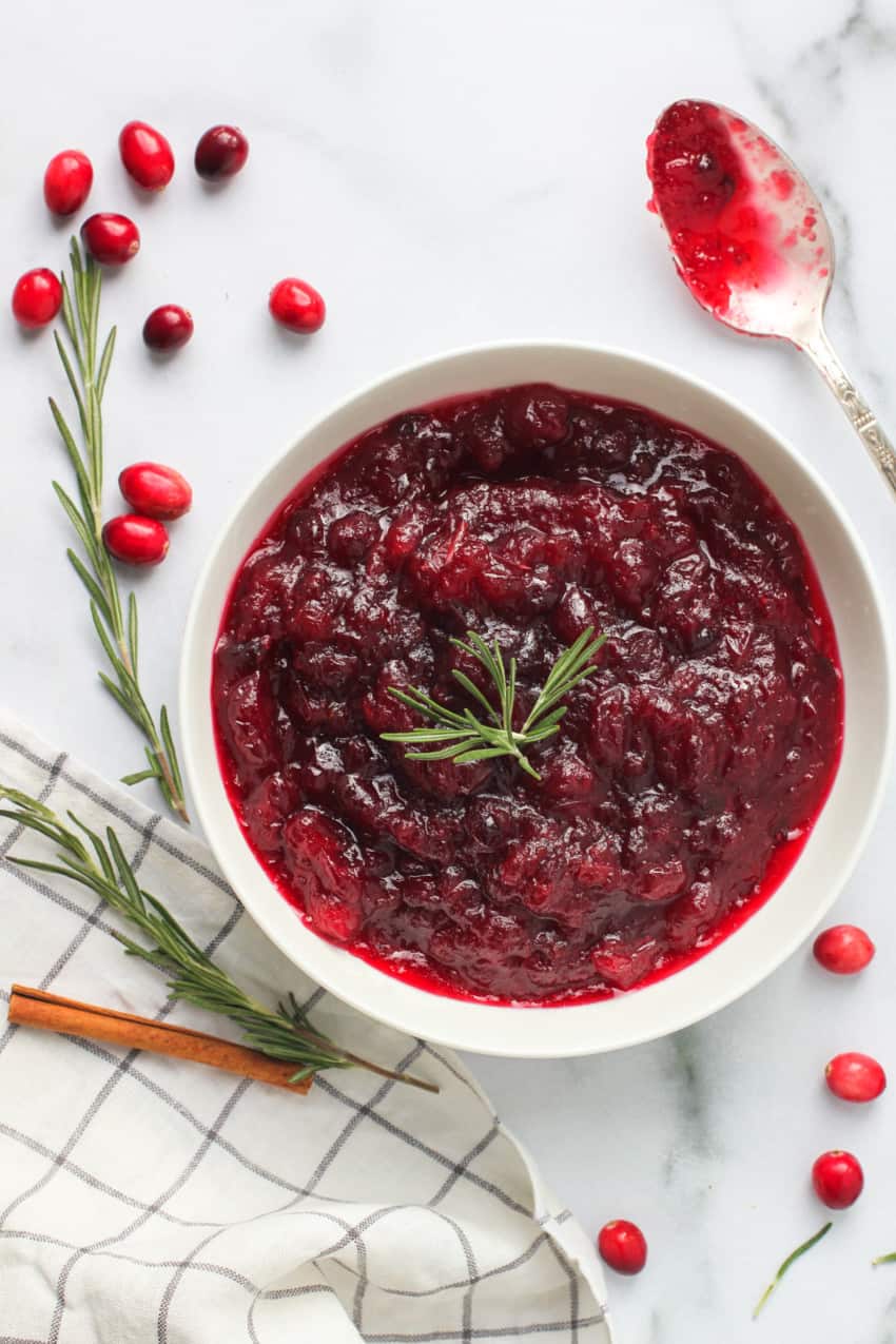 Cranberry apple sauce with rosemary  sprigs and cinnamon stick on the side