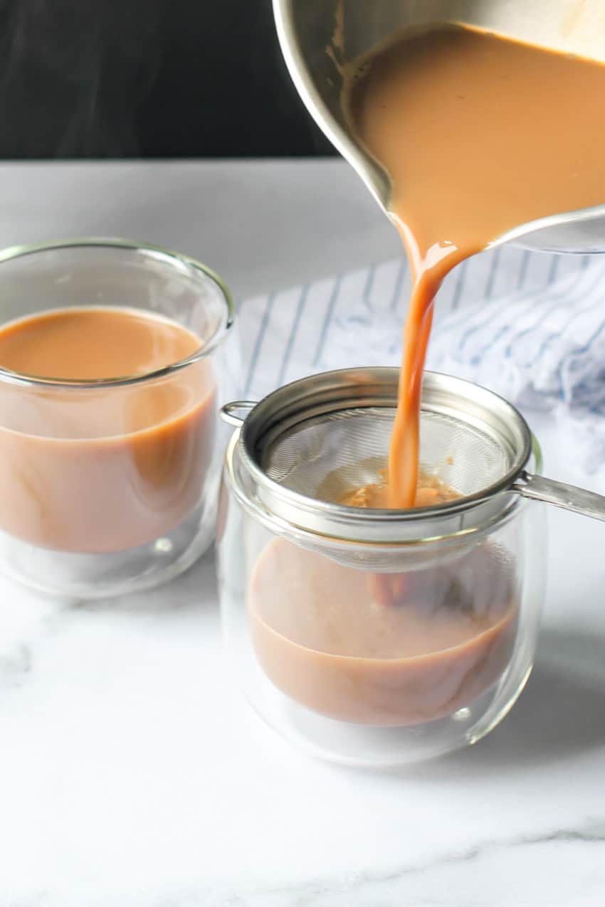 Straining ginger chai in a cup 