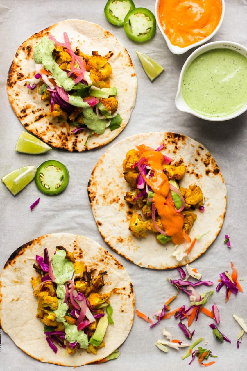 3 tacos served on a white tray 