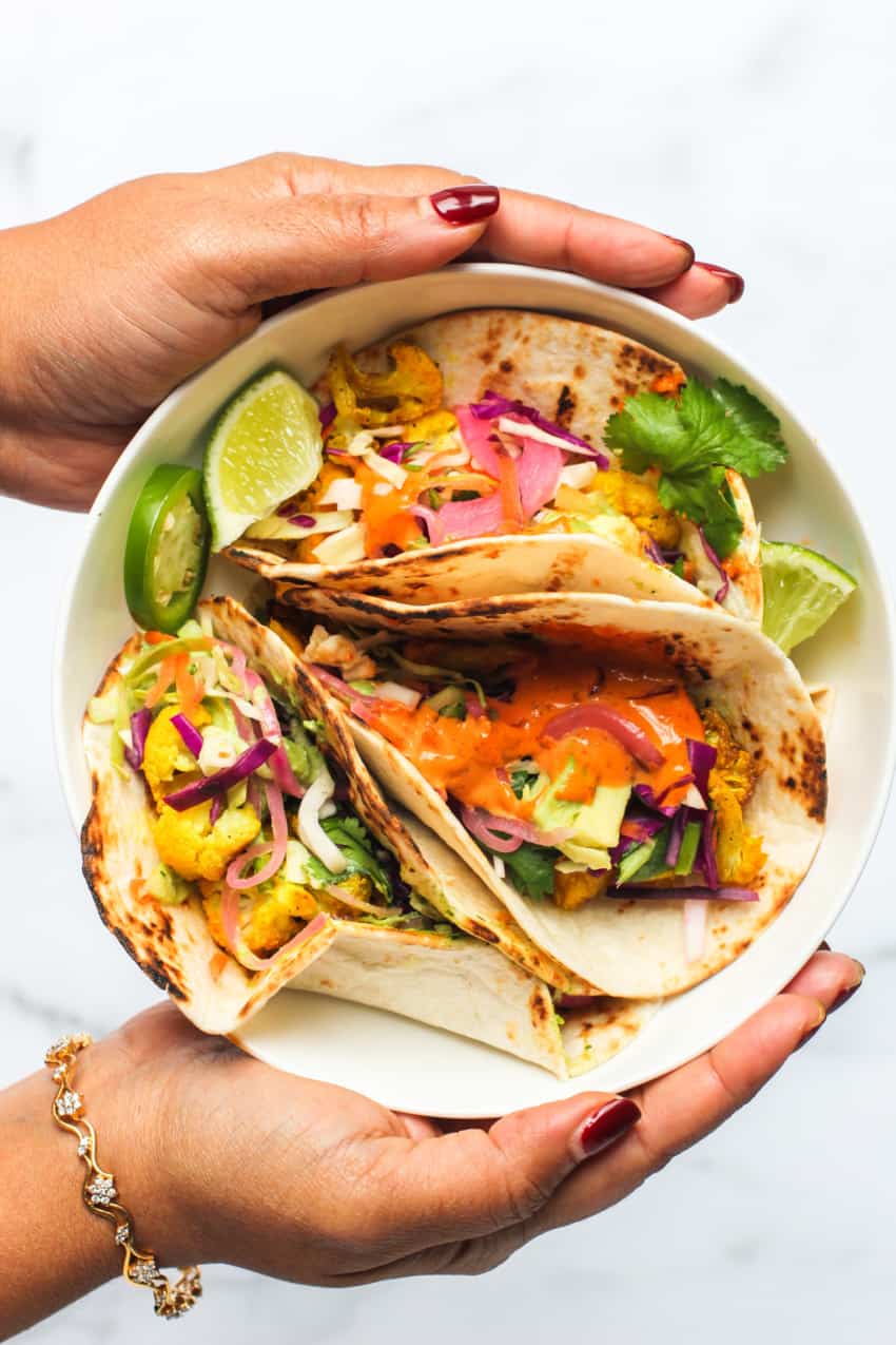 holding a bowl of cauliflower tacos 