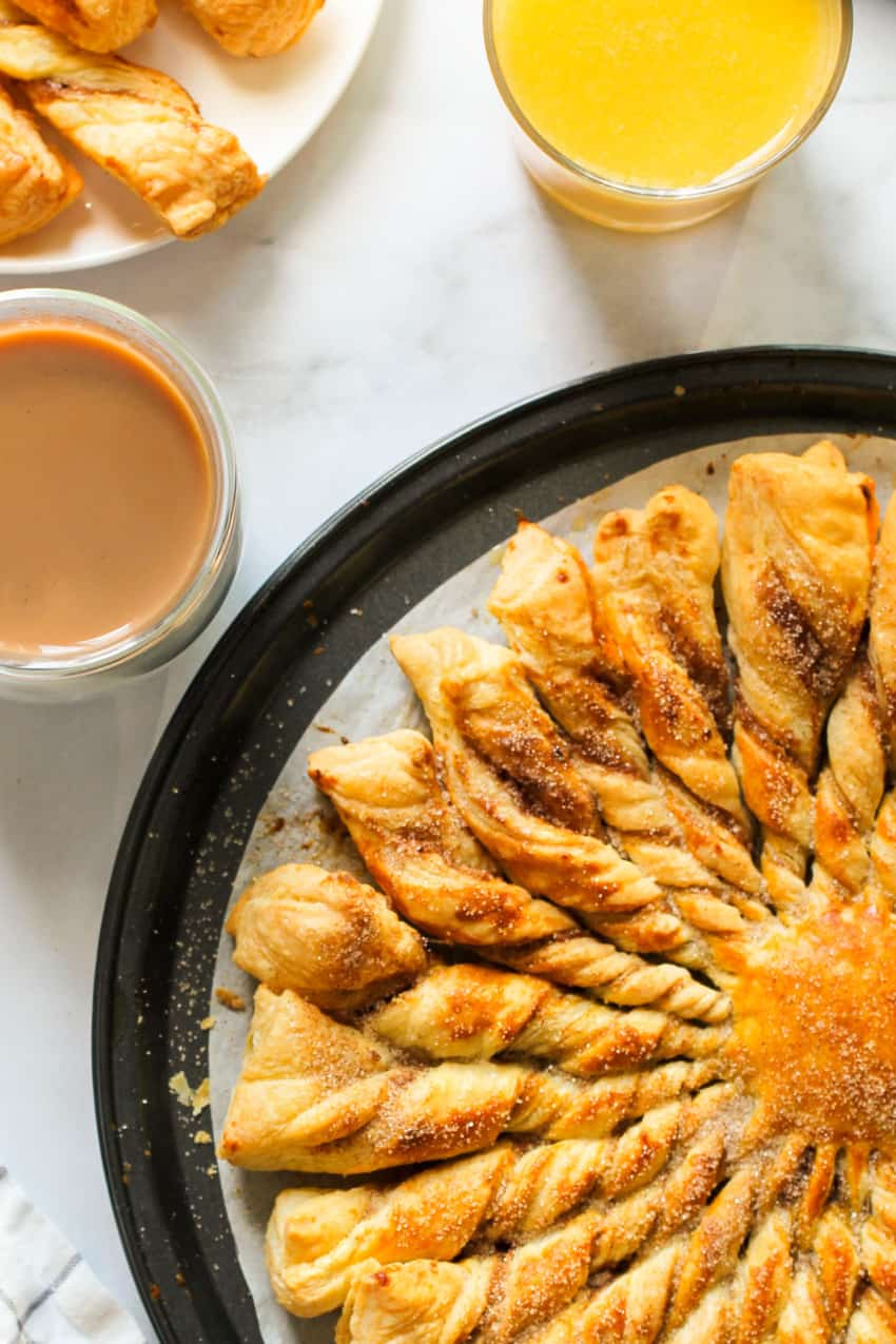 cinnamon sugar khari in a black platter served with tea and orange juice 
