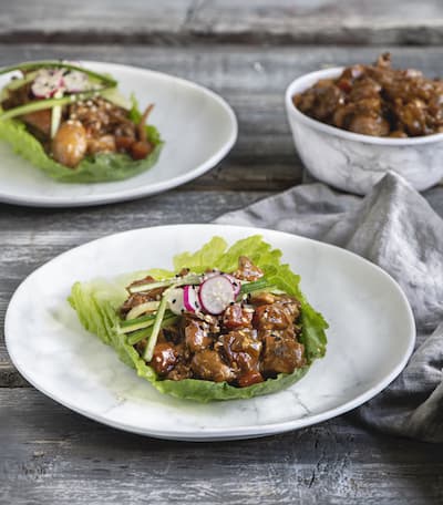 asian chicken on lettuce wrap on white plate
