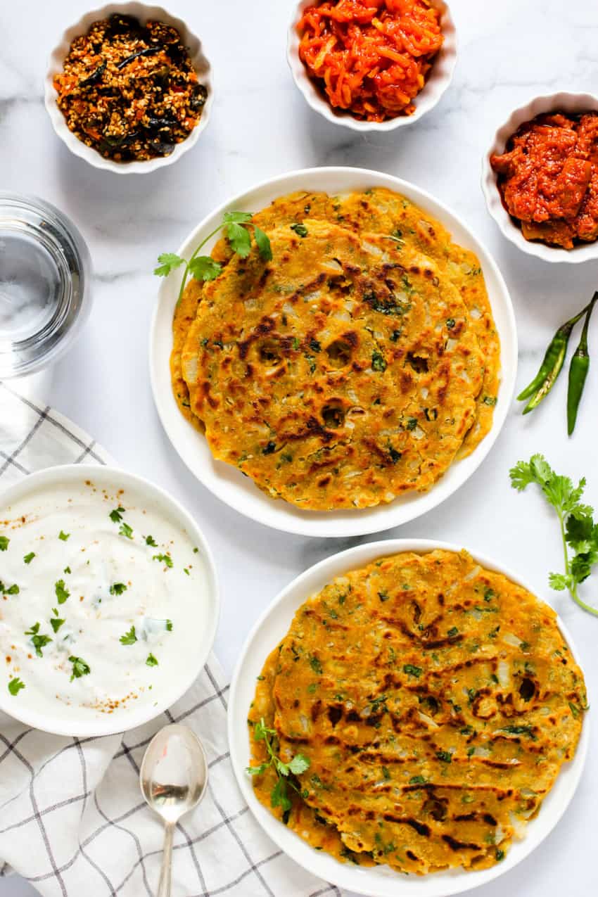 Thalipeeth served with side of pickle, chutney and yogurt