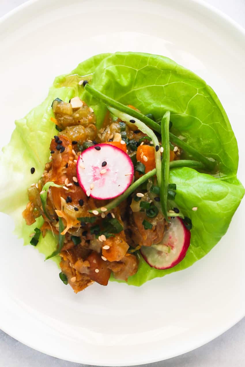 asian chicken on lettuce wrap on white plate