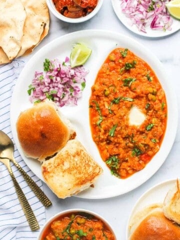pav bhaji served with diced onions, pickle and papad