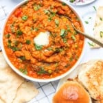 pav bhaji served with diced onions, pickle and papad