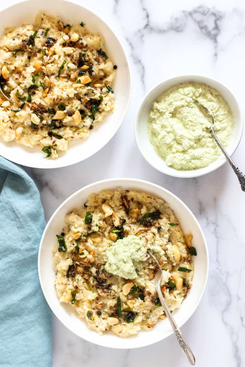 2 white bowls with veg pongal served with coconut chutney 