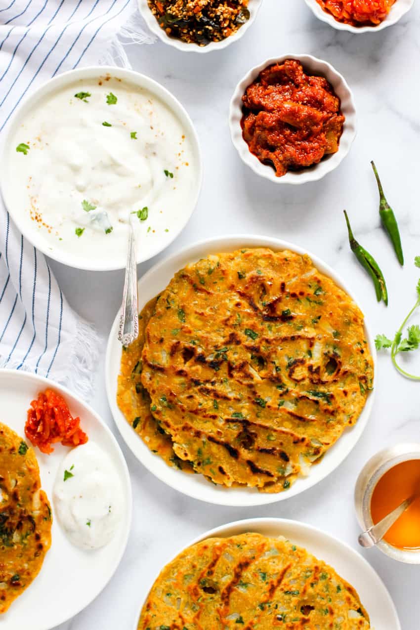 Thalipeeth served with side of pickle, chutney and yogurt