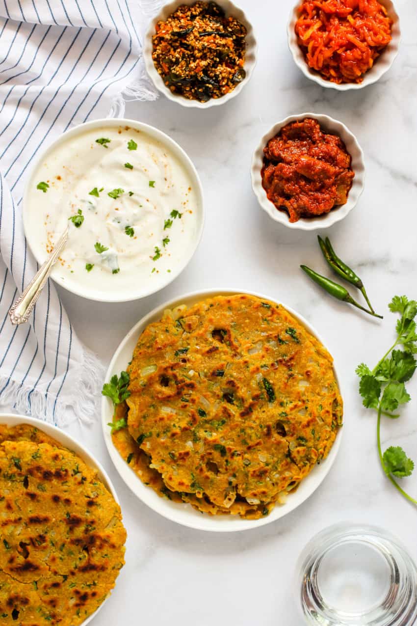 Thalipeeth served with side of pickle, chutney and yogurt