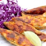 Pompano fish with lime wedge and shredded cabbage