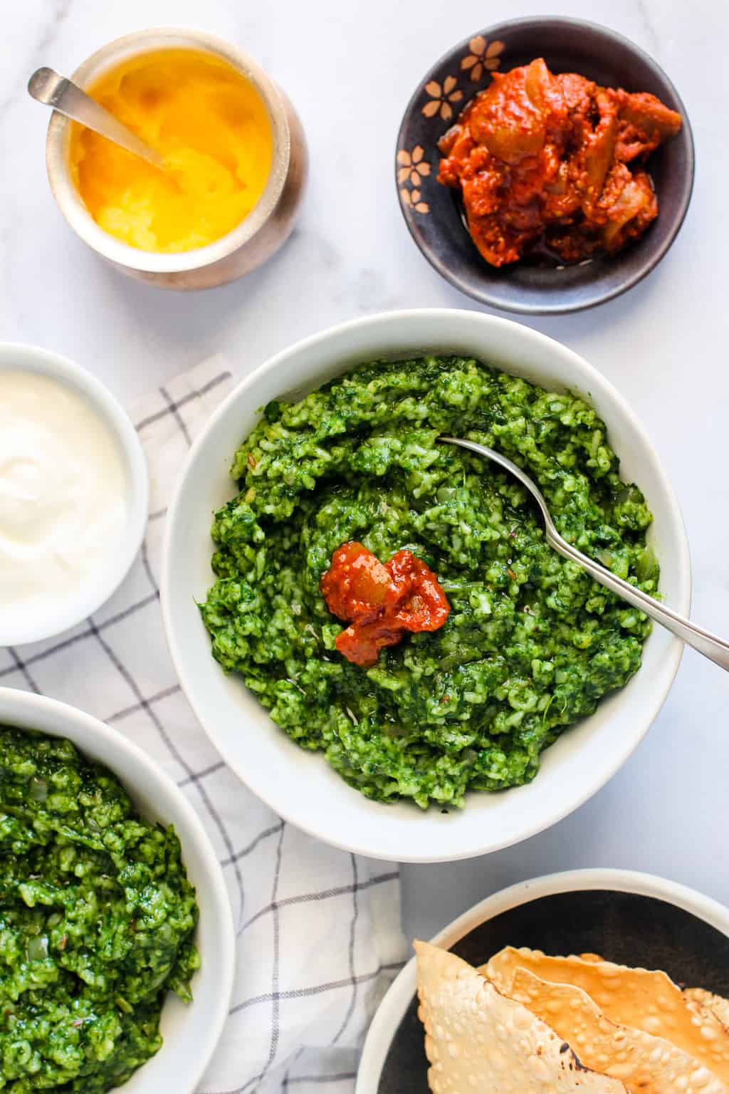 Palak Khichdi served in 2 bowls with pickle and yogurt