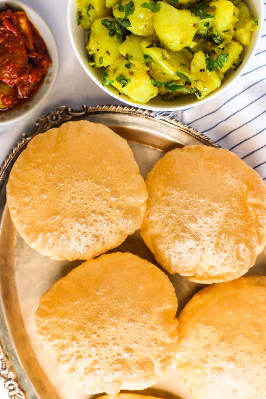 Puri in silver plate with potato bhaji and pickle
