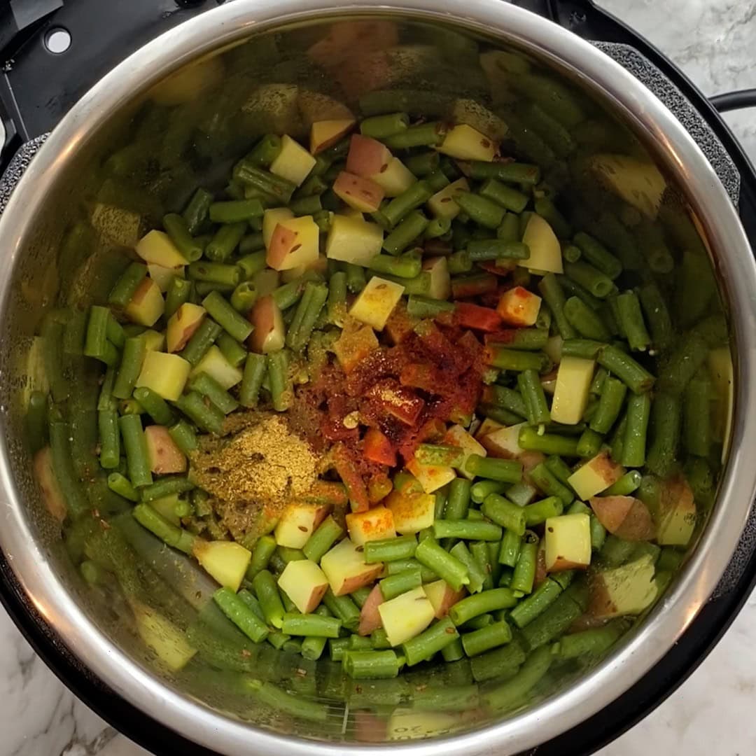 layering ground spices for curried green beans 