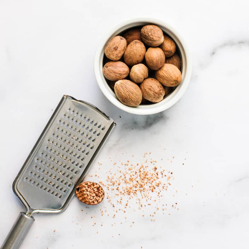 bowl with whole nutmeg and grater
