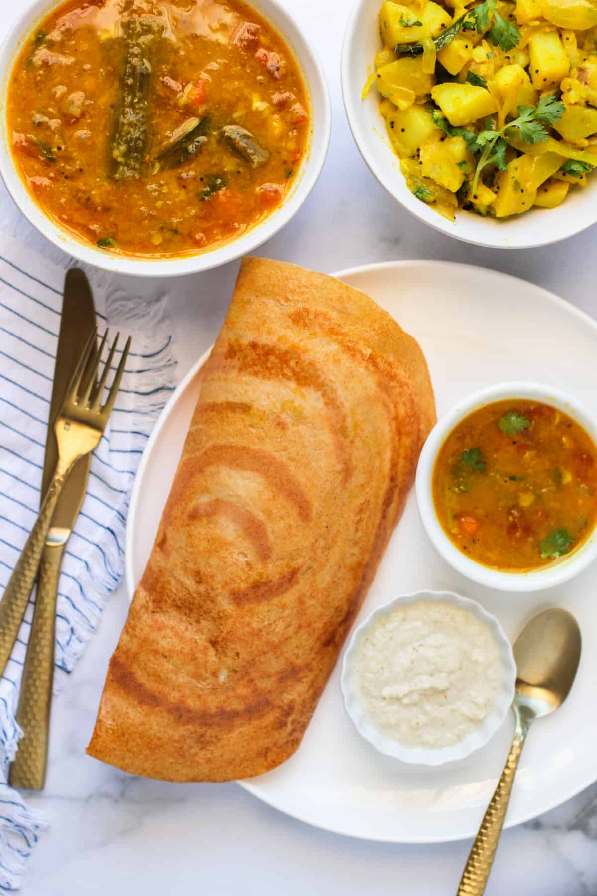 dosa served with sambar, coconut chutny and masala aloo 