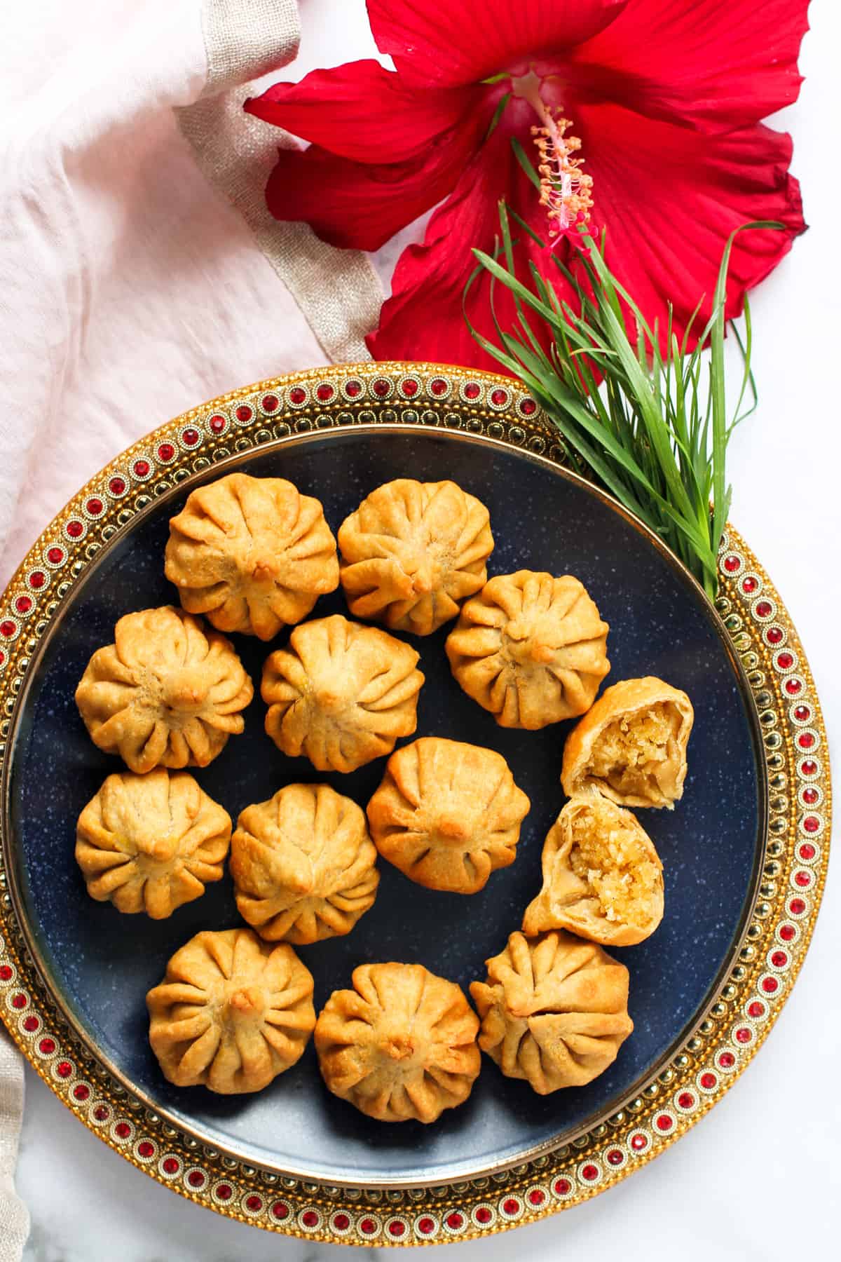 Fried modak next to hibiscus flower
